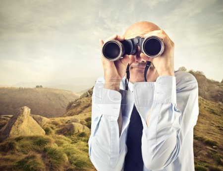 Businessman looking through a binoculars
