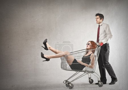 Businessman carrying a woman into a cart
