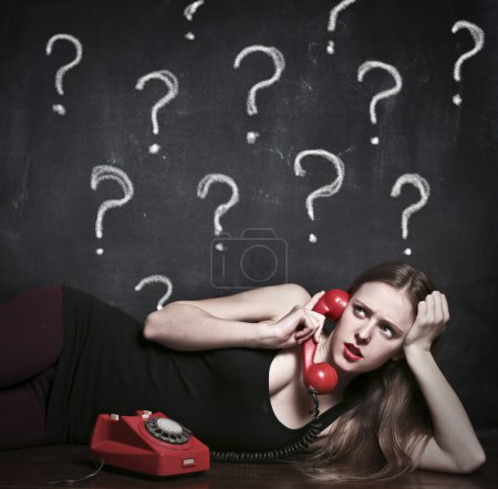 Young doubtful woman speaking at the phone