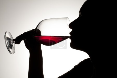silhouette of a woman drinking red wine