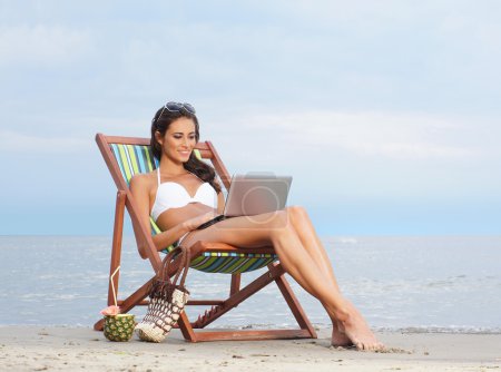 sexy woman with the notebook pc relaxing on the beach