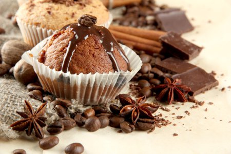 tasty muffin cakes with chocolate, spices and coffee seeds