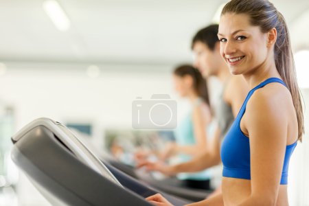 Happy young people on a treadmill