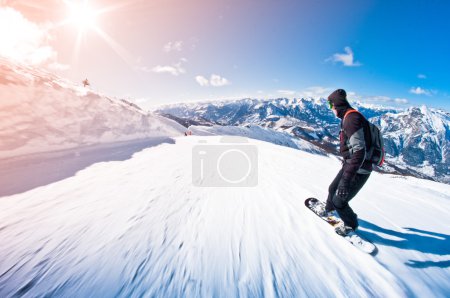 Snowboarder riding fast, motion blur, fisheye shot
