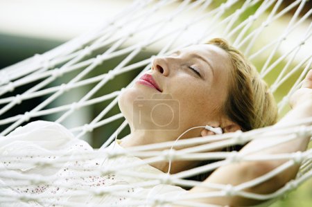 attractive blonde woman laying down on a hammock