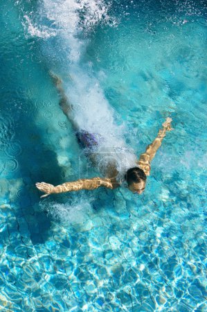 man diving into a swimming pool, forming an arrow shape and leaving a trace behind him.