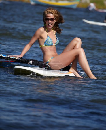 young beautiful woman on windsurfing in water
