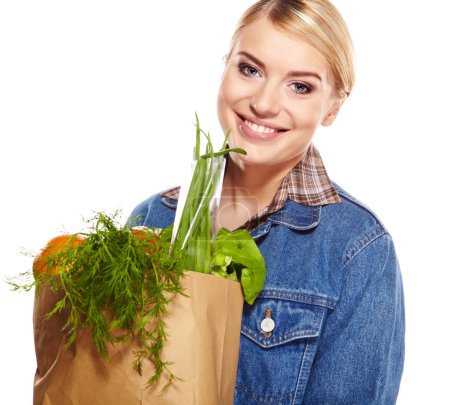 Portrait of happy young woman holding a shopping bag full of gro