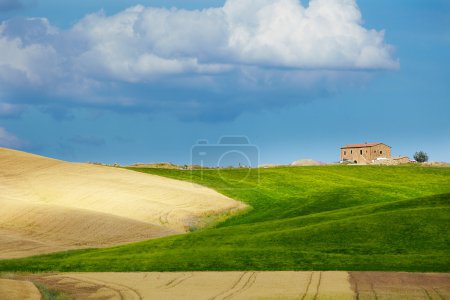 Tuscany landscape with typical farm house on a hill in Val d'Orc