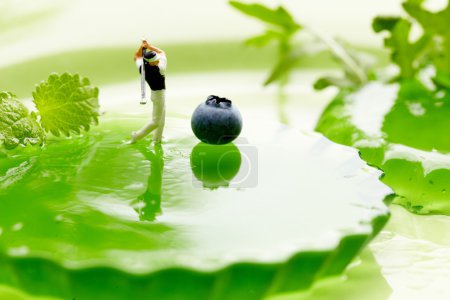 Miniature Figures playing golf on fruits