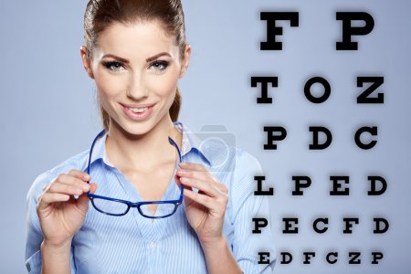 woman with trendy glasses on the background of eye test chart