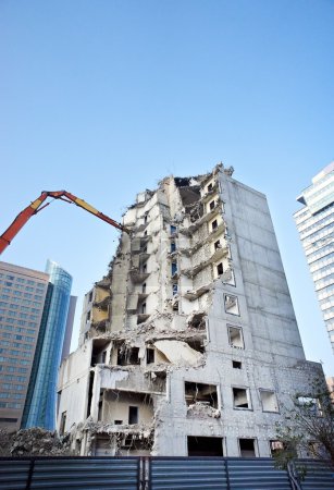 Partly demolished office building with demolition cranes