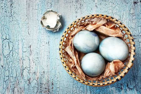 Blue easter eggs in a wattled plate on a textured background. Ru