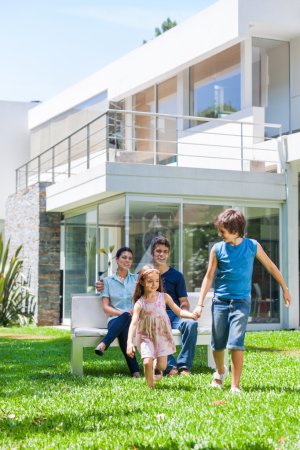 Family in front of big modern house