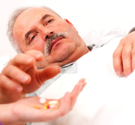 Sick man taking pills