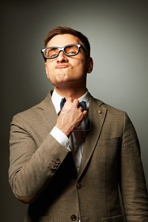 Confident nerd in eyeglasses adjusting his bow-tie