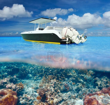 Beach and motor boat with coral reef underwater view