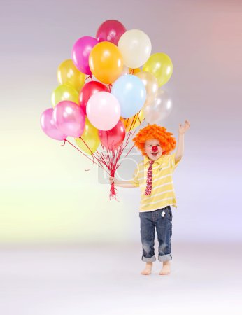 Small boy holding bunch of balloons