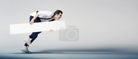 Elegant man running with a white board