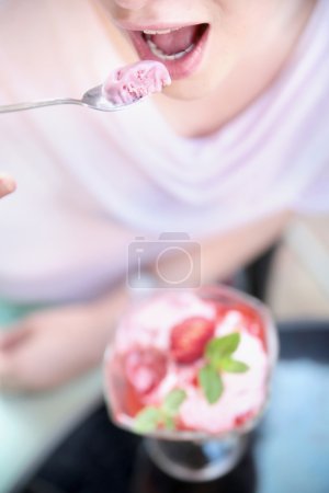 Attractive woman tasting a fruit dessert
