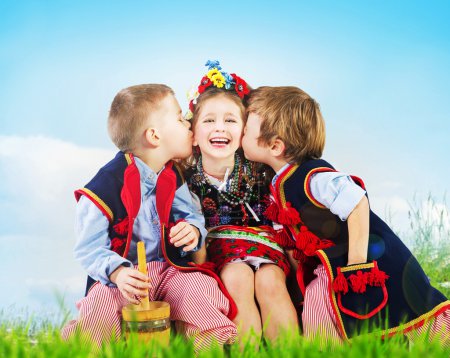 Three cheerful kids wearing national costumes