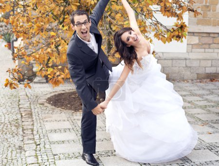 Laughing wedding couple in funny pose