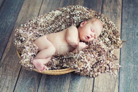 Newborn baby sleeping in wicker basket