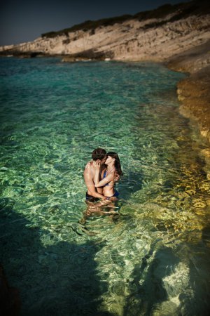 Photo of couple kissing in tropical water