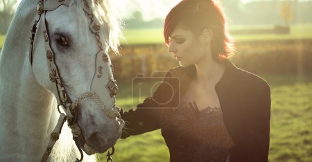 Redhead lady with white horse