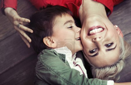 Young boy kissing his mom