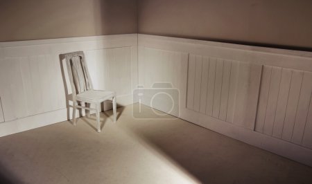Empty interior with chair against wall