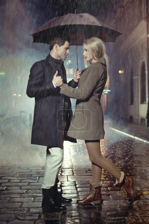 Young couple posing in heavy rain