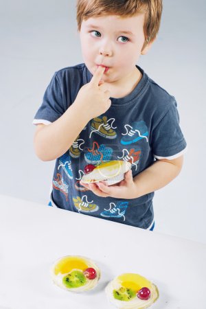 Small boy tasting the fruit cake