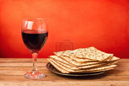 Glass of red wine and matza on wooden table
