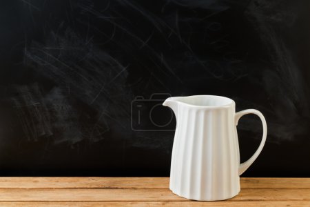 White jug on wooden table