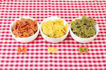 Pasta farfalle in bowls on red tablecloth