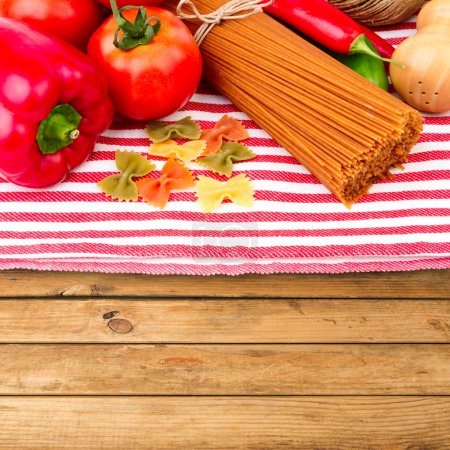 Italian pasta and vegetables on tablecloth