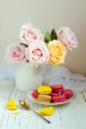 Still life with rose bouquet and macaroons