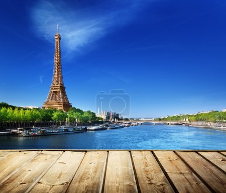 background with wooden deck table and Eiffel tower in Paris