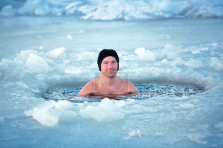 Winter swimming. Man in an ice-hole
