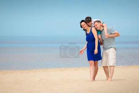 Family of three having fun on tropical beach