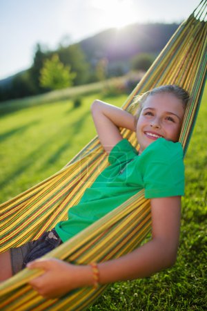 Summer joy  - lovely girl in hammock  in the garden
