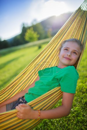 Summer joy  - lovely girl in hammock  in the garden