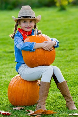 Autumn harvest -  lovely girl and large pumpkins