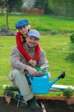 Gardening, planting - young girl helping father in the garden
