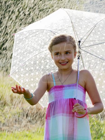 	Summer rain - happy girl with an umbrella in the rain