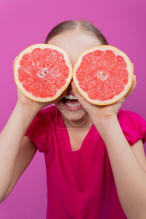 Grapefruit - a young girl has fun with healthy fruits
