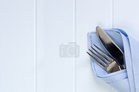 Cutlery in Napkin over Timber Background