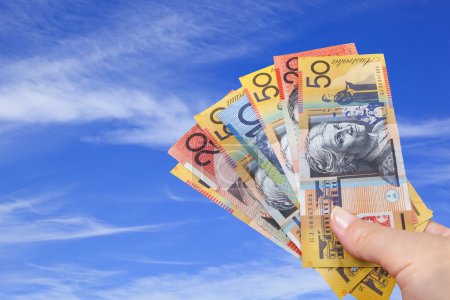 Handful of Australian Money over Blue Sky.