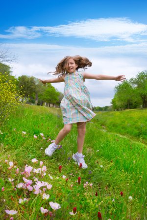 happy children girl jumping on spring poppy flowers